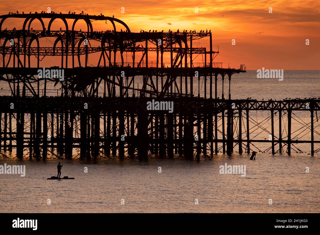 Pédalo silhoueté sur la jetée ouest abandonnée au coucher du soleil, Brighton, Angleterre.Construit en 1866 et fermé en 1975, le quai est toujours classé de catégorie I et un site bien connu. Banque D'Images
