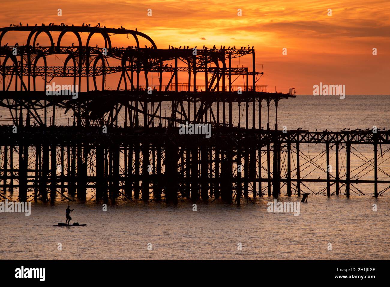 Pédalo silhoueté sur la jetée ouest abandonnée au coucher du soleil, Brighton, Angleterre.Construit en 1866 et fermé en 1975, le quai est toujours classé de catégorie I et un site bien connu. Banque D'Images
