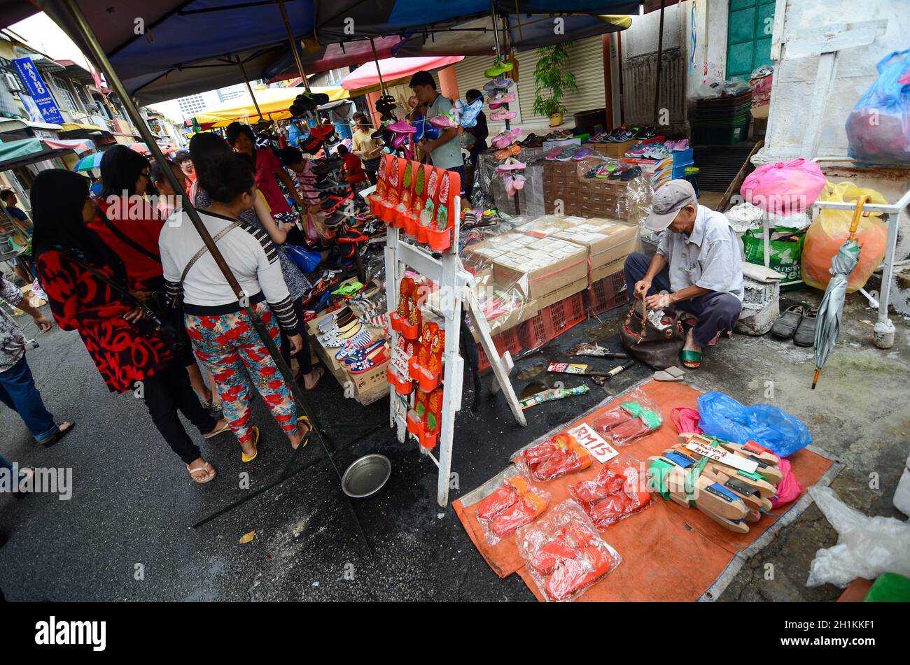 Georgetown, Penang/Malaysia - juin 17 2016: Vendeur de chaussures en bois rouge au marché du matin dans la vieille rue. Banque D'Images