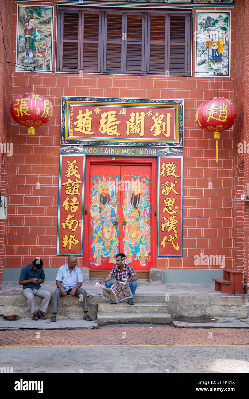 Georgetown, Penang/Malaysia - août 14 2016 : un résident indien a un chat de chit devant le temple chinois. Banque D'Images