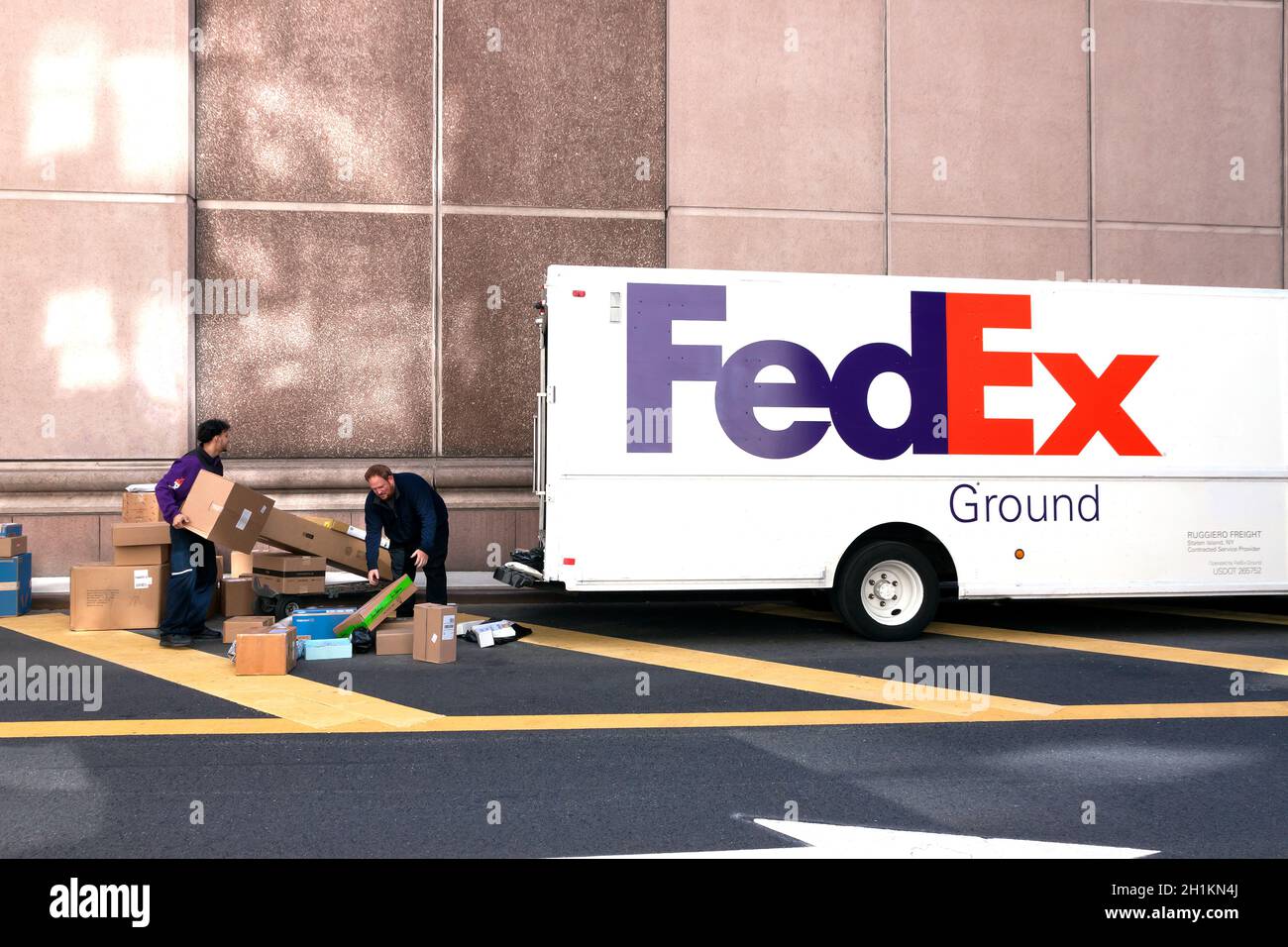 Les employés de livraison FedEx trient les boîtes dans la rue. Banque D'Images