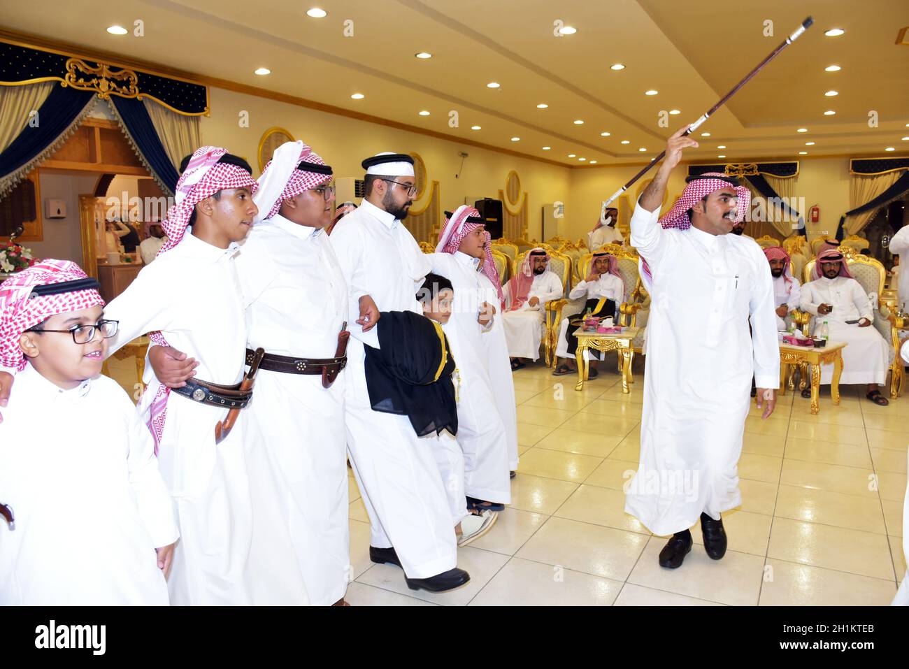 2020 juillet, salle de mariage Riyad, Arabie Saoudite, hommes saoudiens célébrant et appréciant la danse traditionnelle avec des objets culturels entre les mains pendant l'événement de mariage Banque D'Images