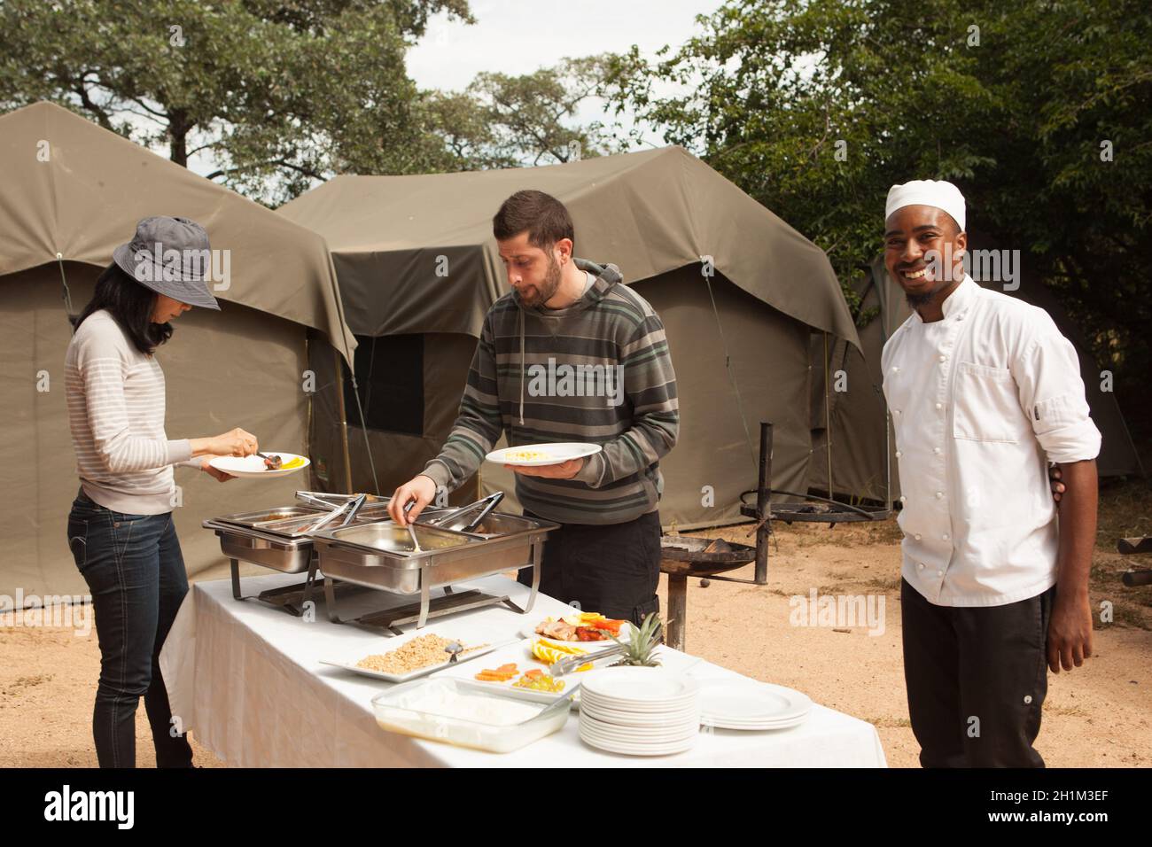 Les touristes mangent le dîner à l'extérieur de la tente au parc national Kruger, Afrique du Sud Banque D'Images