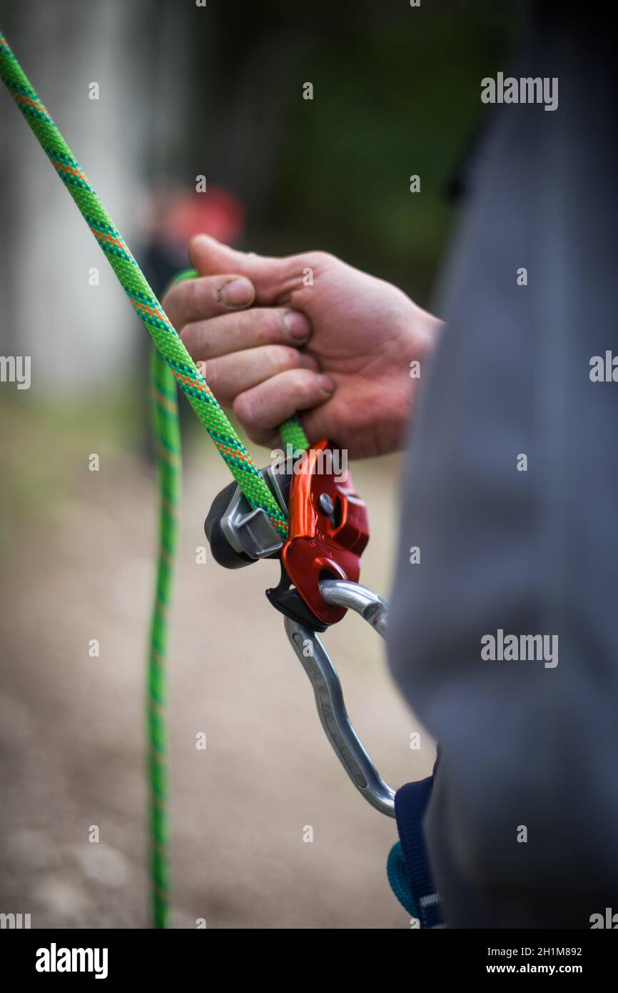 Gros plan des mains d'un homme qui utilisent un dispositif de transmission en bande d'escalade. Banque D'Images Gros plan des mains d'un homme qui utilisent un dispositif de transmission en bande d'escalade. Banque D'Images
