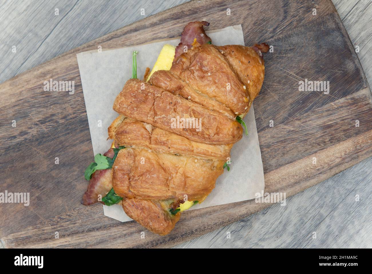 Vue sur le dessus du bacon et des œufs servis à l'intérieur d'un petit déjeuner croissant pour un sandwich à emporter. Banque D'Images
