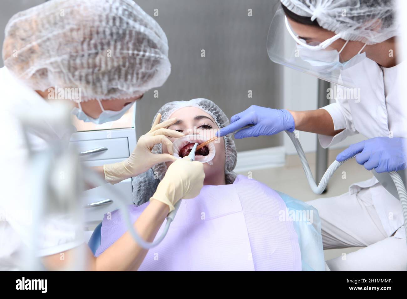 Le dentiste et son assistant effectuent un nettoyage dentaire professionnel et une hygiène bucco-dentaire professionnelle.Prévention des caries et des maladies des gencives.Enrouleur dans la bouche.Haut vi Banque D'Images Le dentiste et son assistant effectuent un nettoyage dentaire professionnel et une hygiène bucco-dentaire professionnelle.Prévention des caries et des maladies des gencives.Enrouleur dans la bouche.Haut vi Banque D'Images