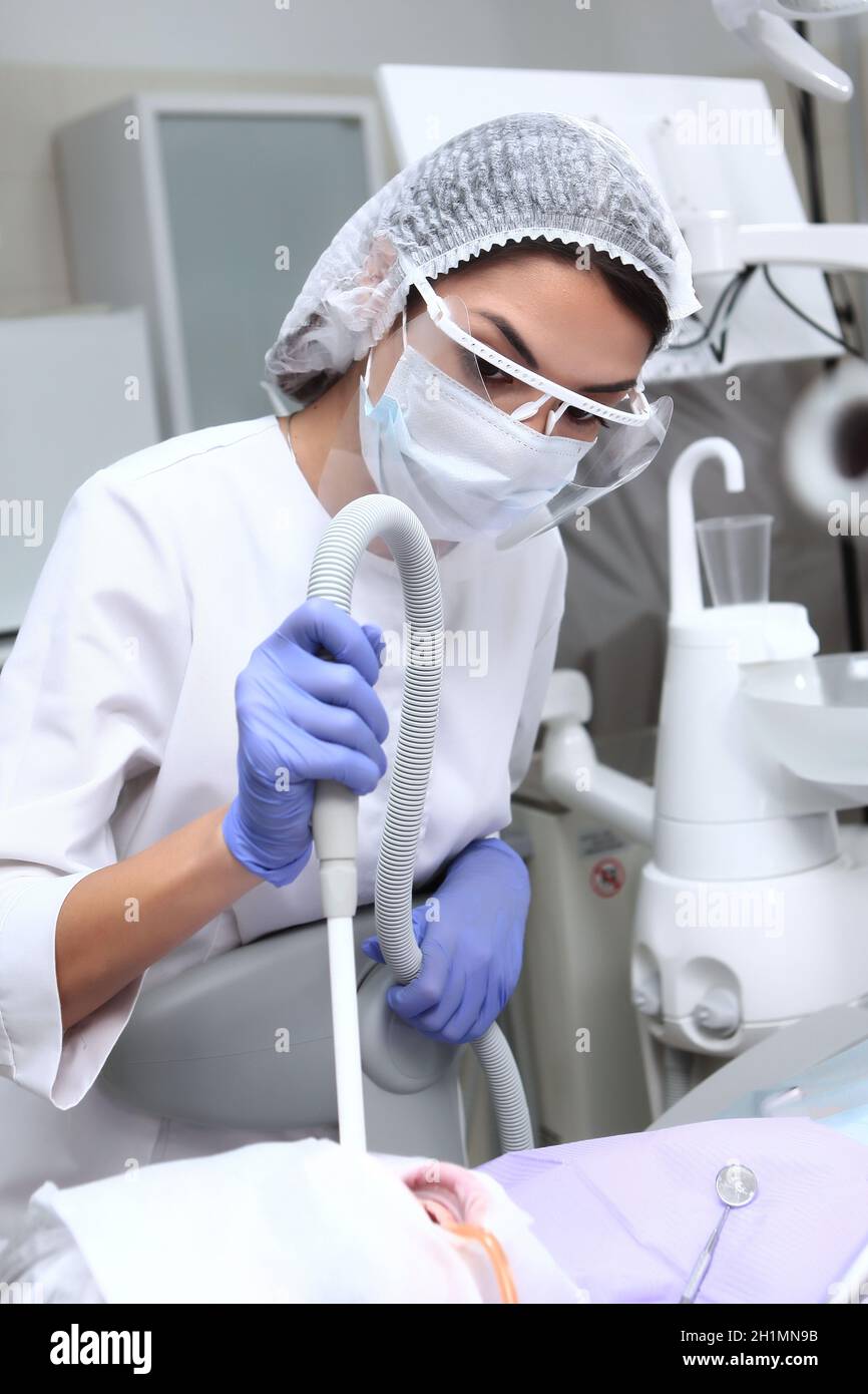 Assistant dentaire au travail.L'assistant tient une pompe de salive.Prévention des caries.Le concept de santé.Photo verticale. Banque D'Images Assistant dentaire au travail.L'assistant tient une pompe de salive.Prévention des caries.Le concept de santé.Photo verticale. Banque D'Images