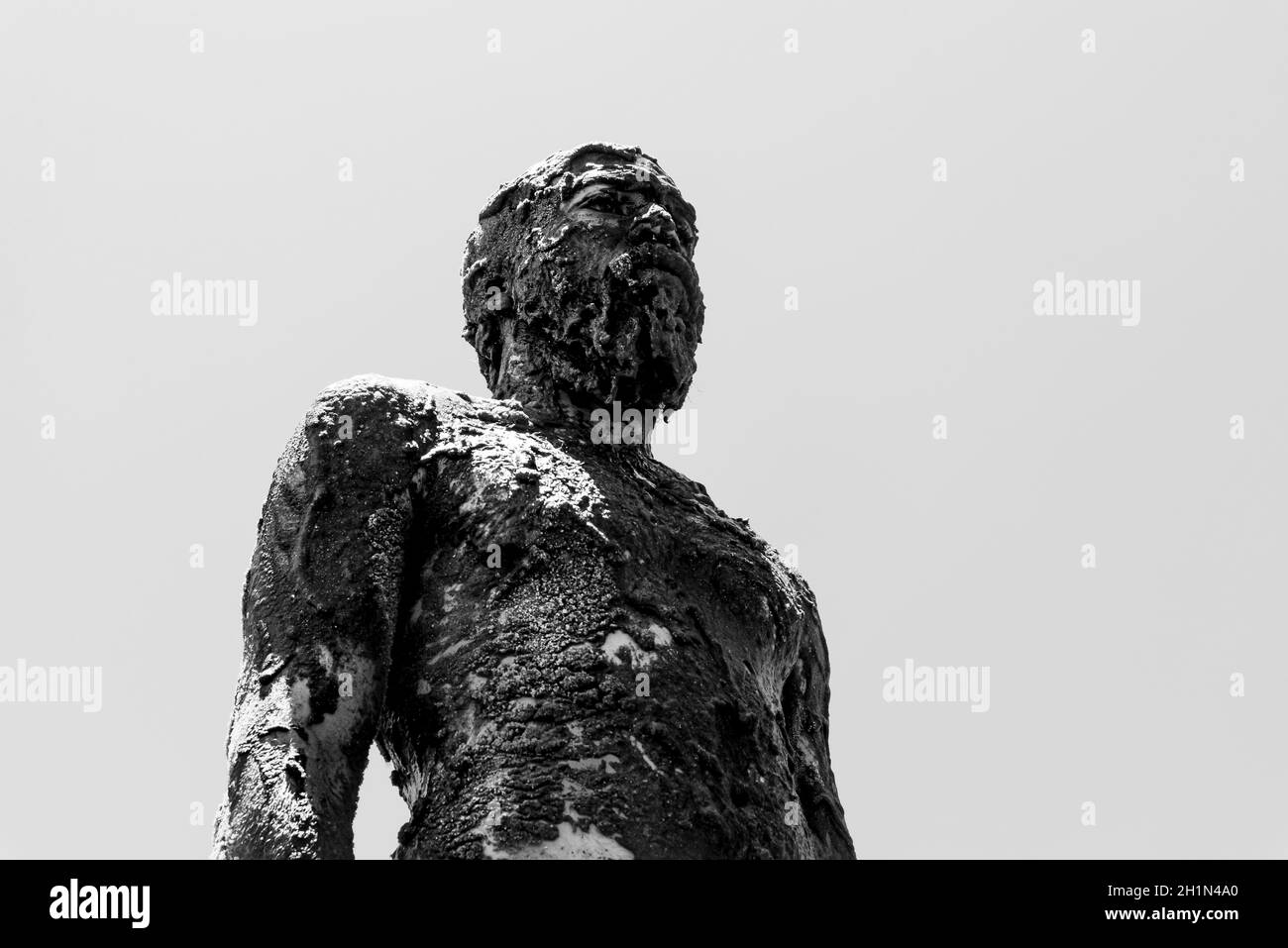 Homme couvert de pétrole sur la plage de Porto da Barra à Salvador, Bahia, en signe de protestation contre le déversement de pétrole par un navire sur les plages du Brésil. Banque D'Images