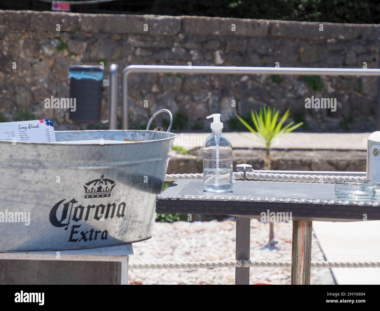 Tin ina Beach café avec logo et inscription 'Corona Extra' de la marque de commerce de la bière en plus du désinfectant de protection Corona - image symbolique Banque D'Images