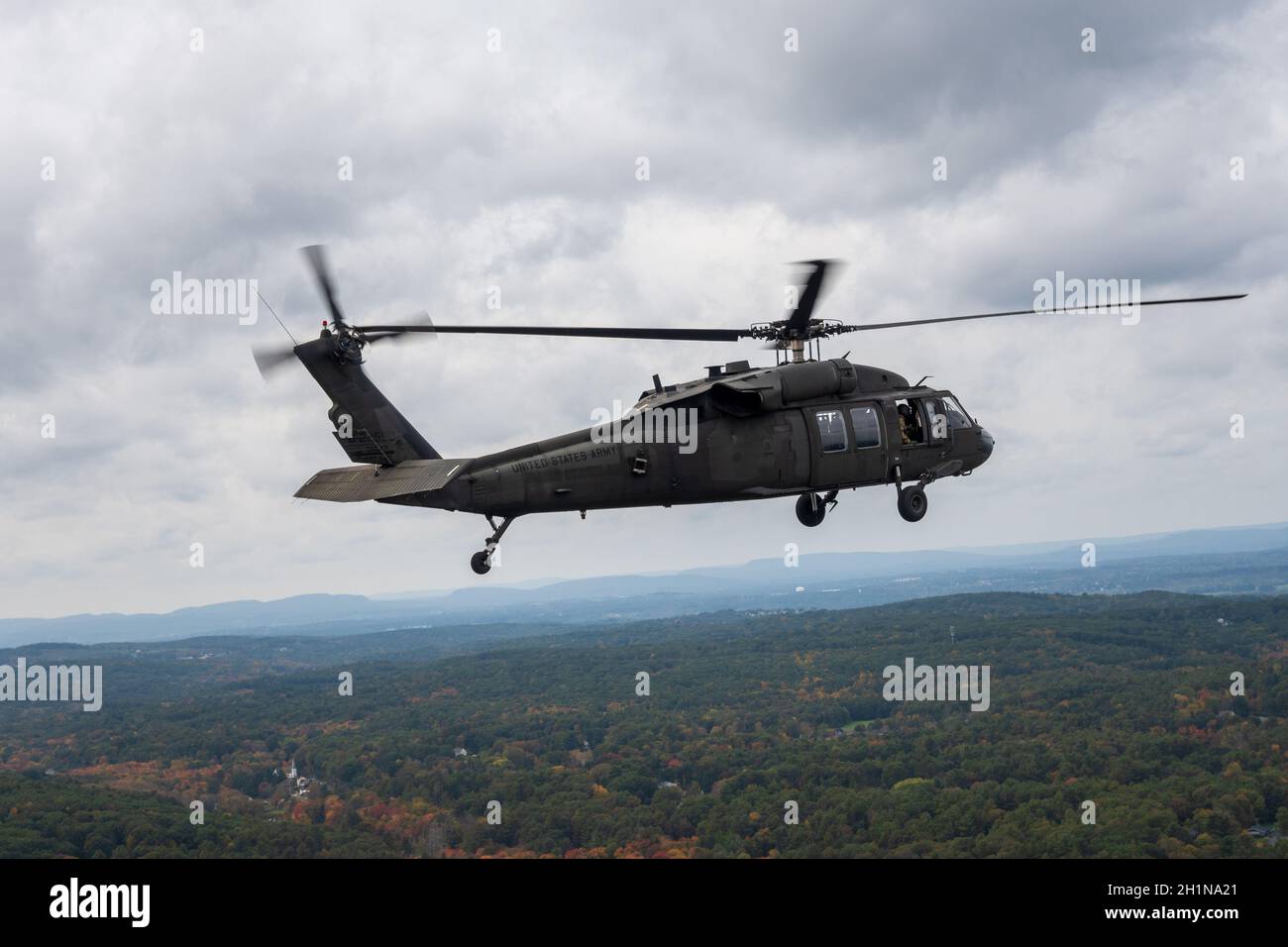 Un équipage de la Garde nationale de l'armée américaine vole un hélicoptère UH-60 en route pour effectuer un survol au-dessus du champ de Rentschler à East Hartford, Connecticut, le 16 octobre 2021.Le survol était en faveur du match de football UConn contre Yale. Banque D'Images