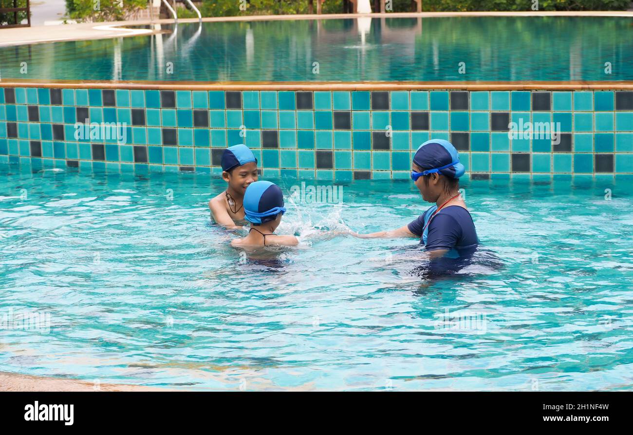 Filles et garçons jouant dans la piscine Banque D'Images