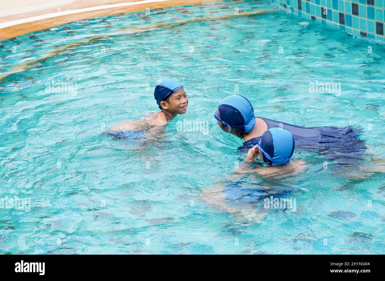Filles et garçons jouant dans la piscine Banque D'Images