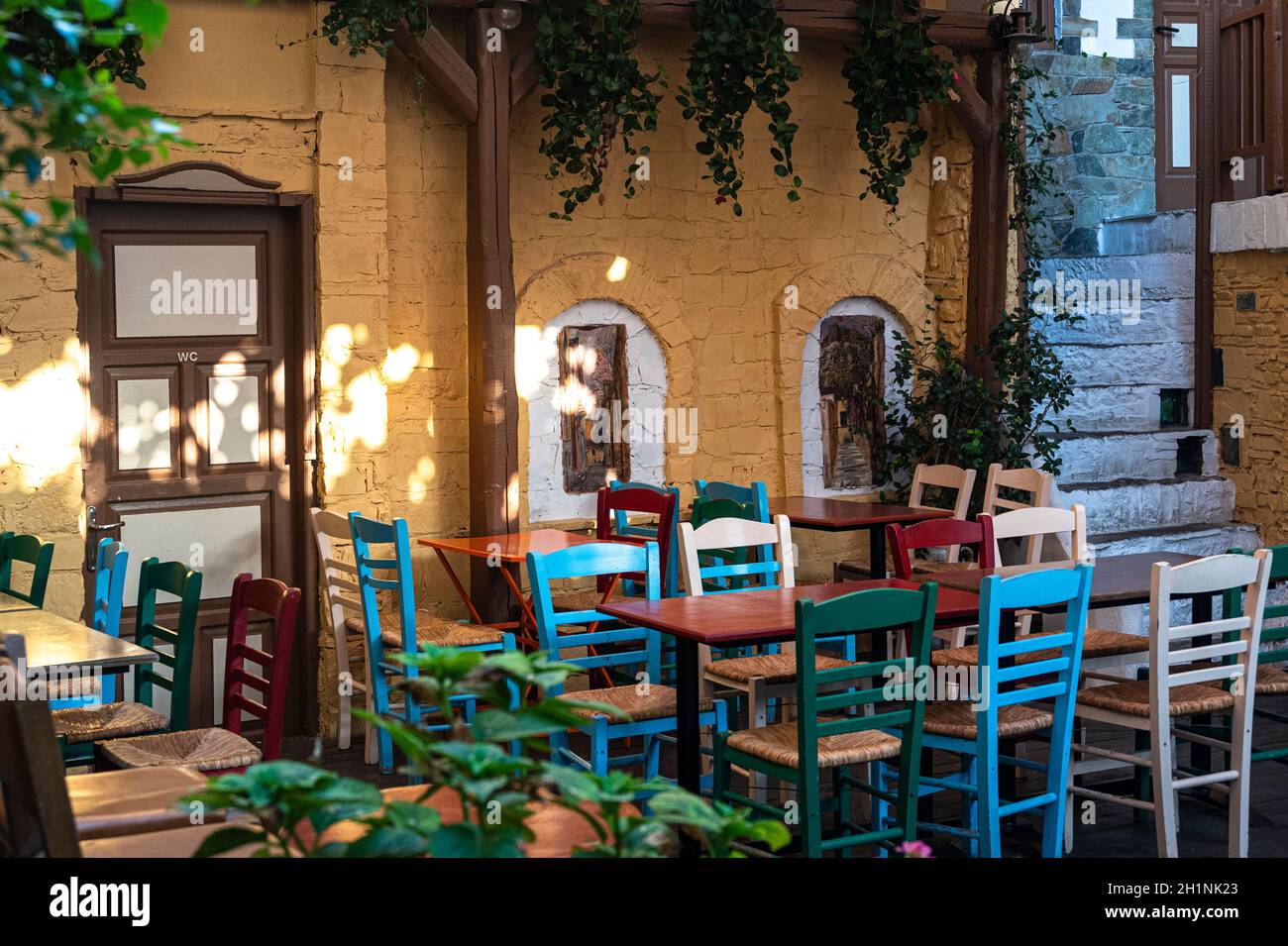 Chaises et tables colorées dans un café sur les escaliers publics de Yiasemi pour dîner dehors à Athènes, Grèce pendant l'été Banque D'Images