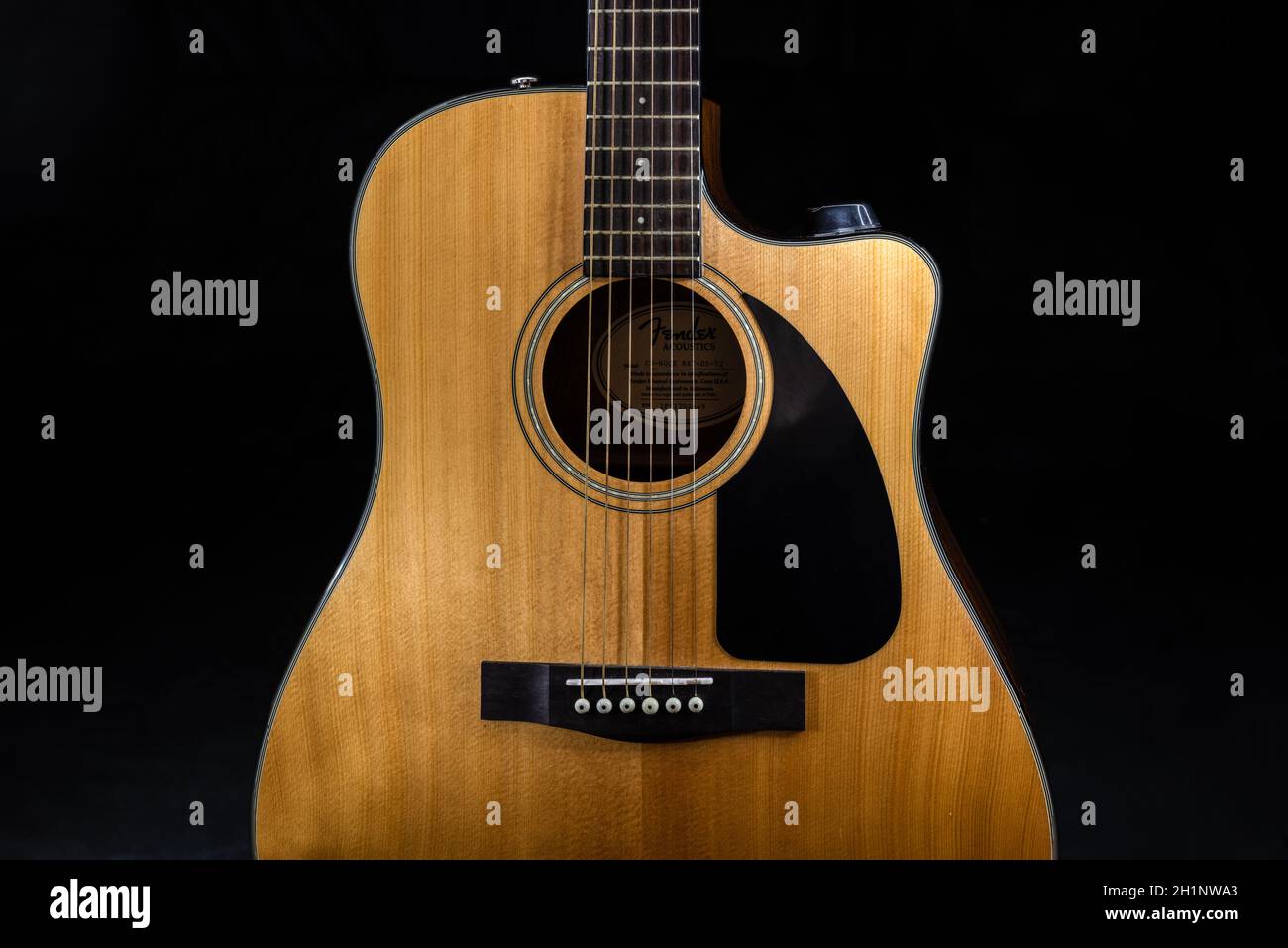 Guitare acoustique classique à six cordes Fender CD-60 avec un son jaune carte et plaque à gratter noire sur fond noir isolé Banque D'Images