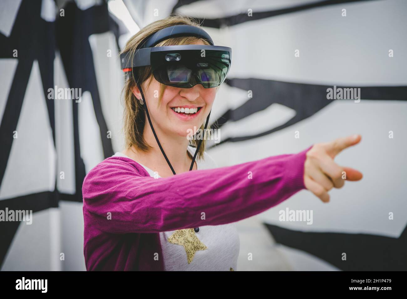 La jeune femme utilise des lunettes de réalité virtuelle ou un casque Banque D'Images
