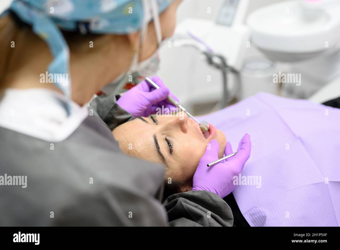 Dentiste hygiéniste faisant le nettoyage hygiénique oral en dentisterie pour la jeune femme.Utilisation d'un équipement électrique professionnel, d'une perceuse à dents pour brosser les dents Banque D'Images