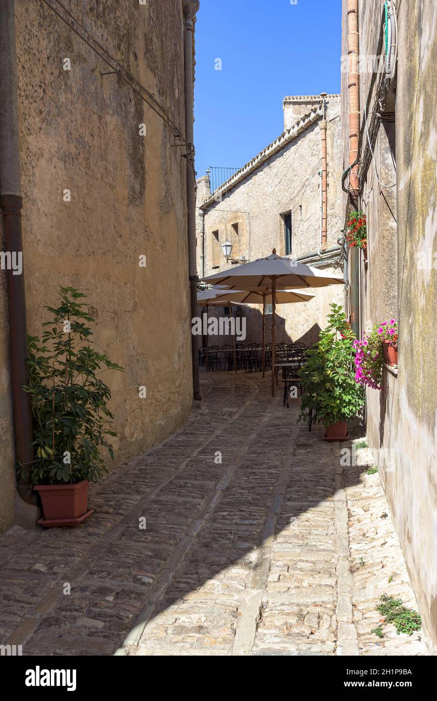 Tables de restaurant dans la rue étroite de la célèbre ville ancienne d'Erice, Sicile, Sicile Banque D'Images