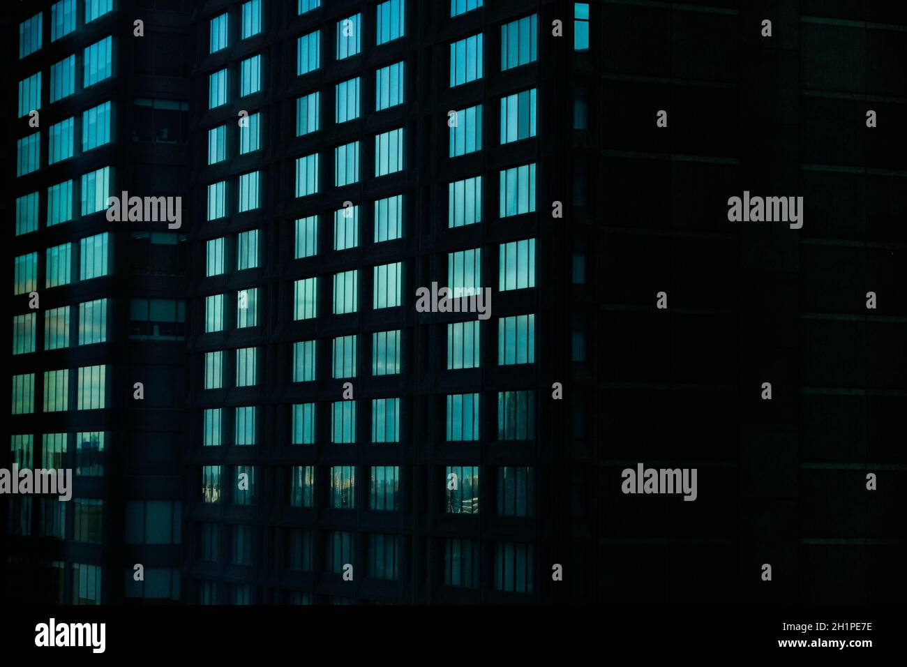 La lumière de Moody se reflète dans les fenêtres d'un édifice moderne de la rue Sherbrooke, dans la section du Golden Square Mile de Montréal, Québec, Canada. Banque D'Images