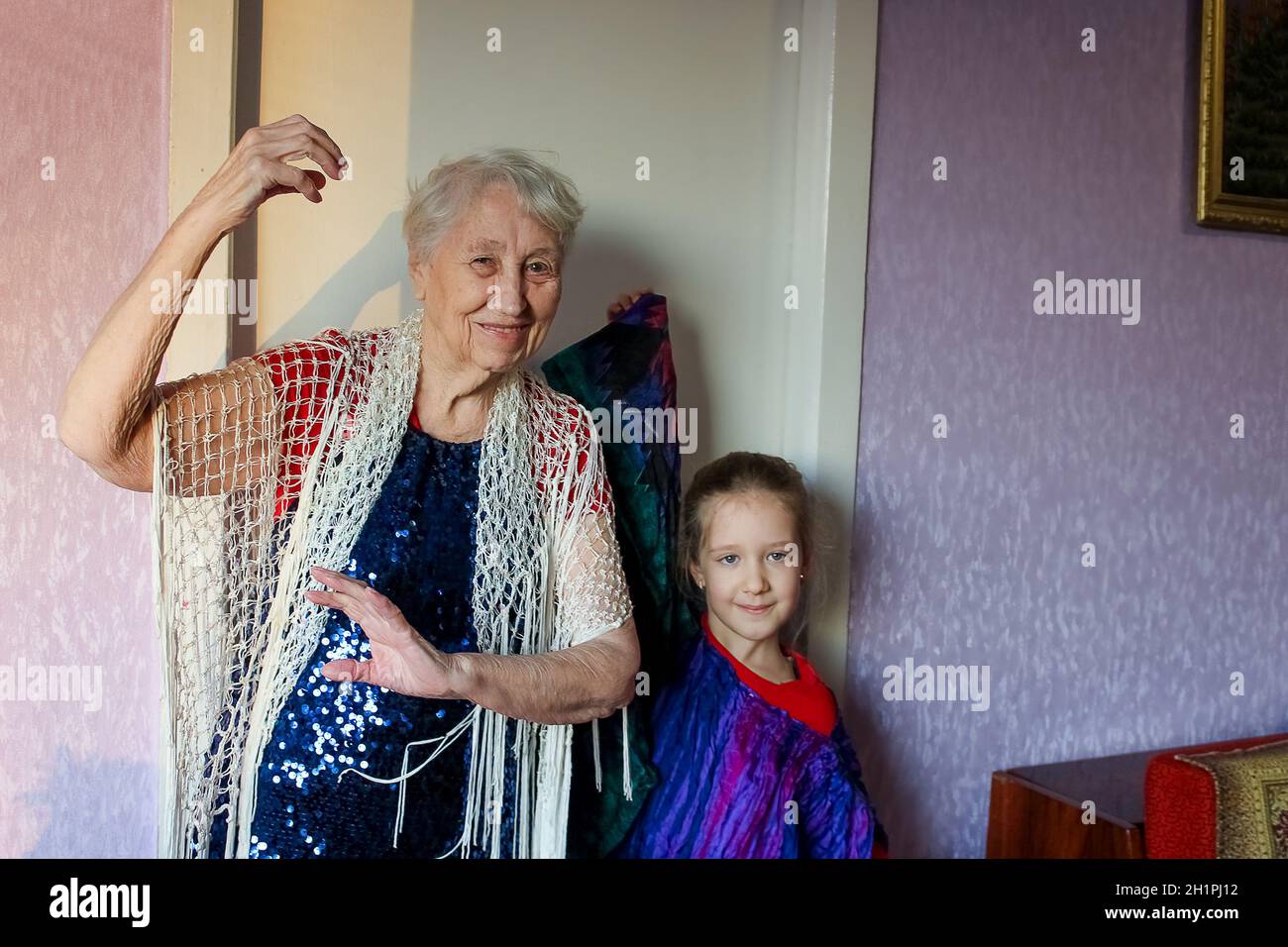 Bonne souriante drôle femme âgée portant des perles dansant à la maison - grand-mère avec grande-petite-fille Banque D'Images