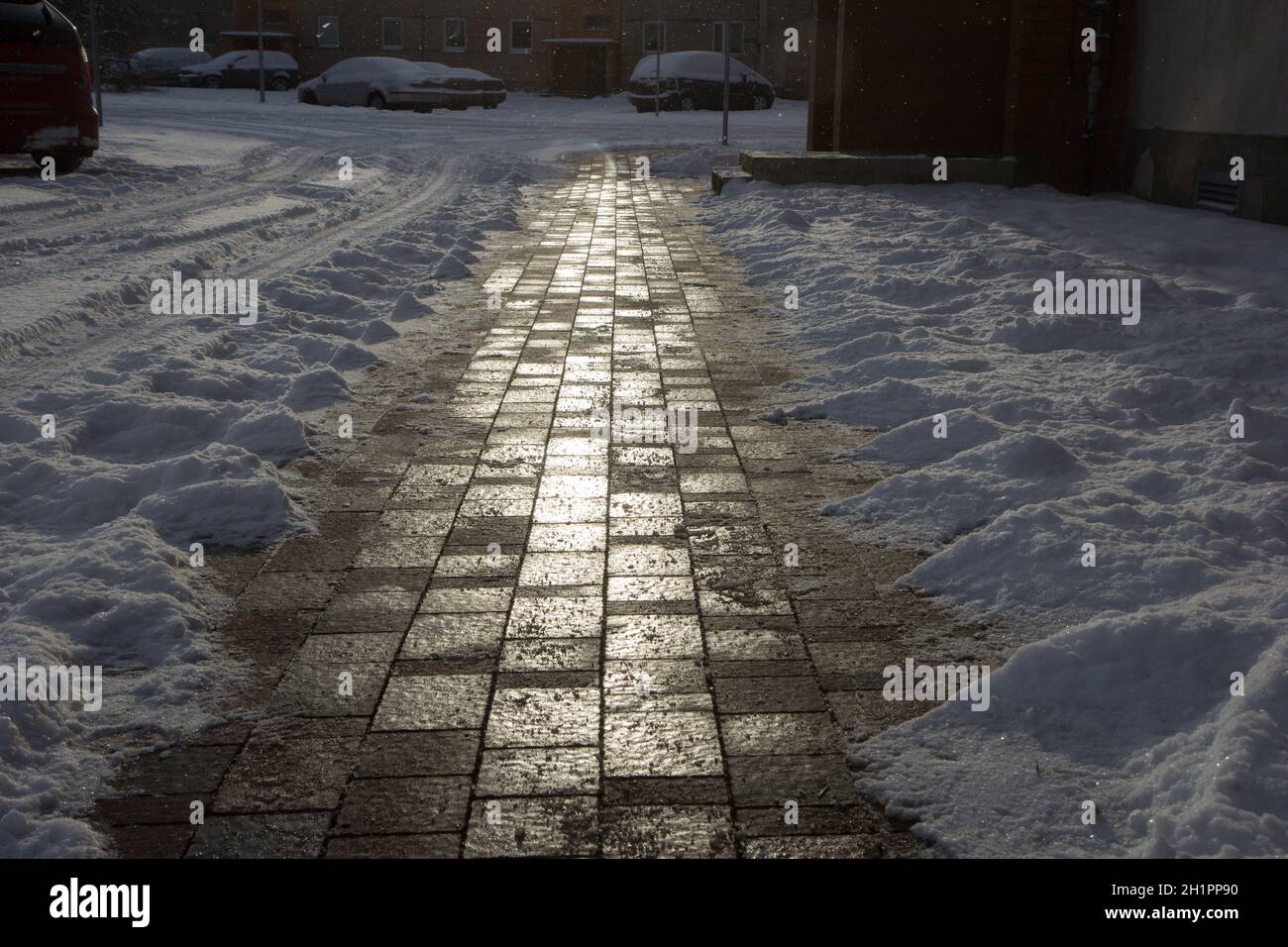 Un trottoir après la tempête de neige est dégagé de la neige. Le soir, lumière du soleil. Banque D'Images