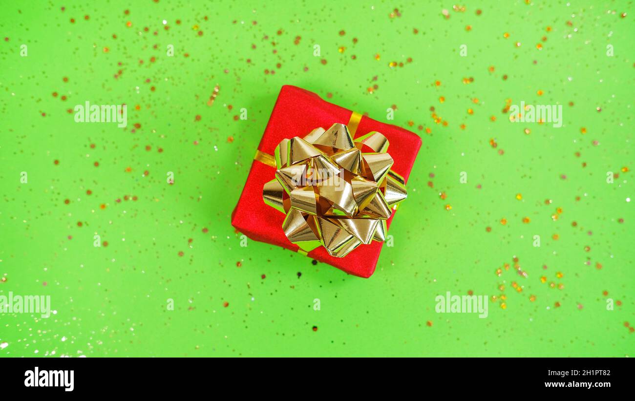 Cadeau ou cadeau boîte et confetti sur fond rouge et vert festif .Composition de la couche plate pour noël Banque D'Images