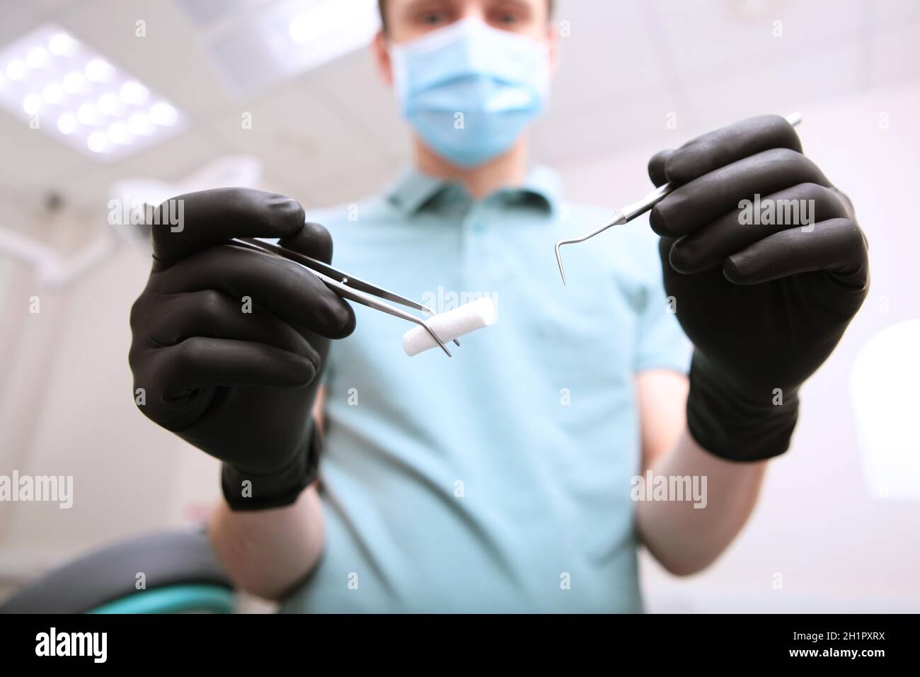 Mains de dentiste en gants de latex noir avec instruments médicaux .Visage  non mis au point.POV.Copier l'espace.Vue de dessous Photo Stock - Alamy