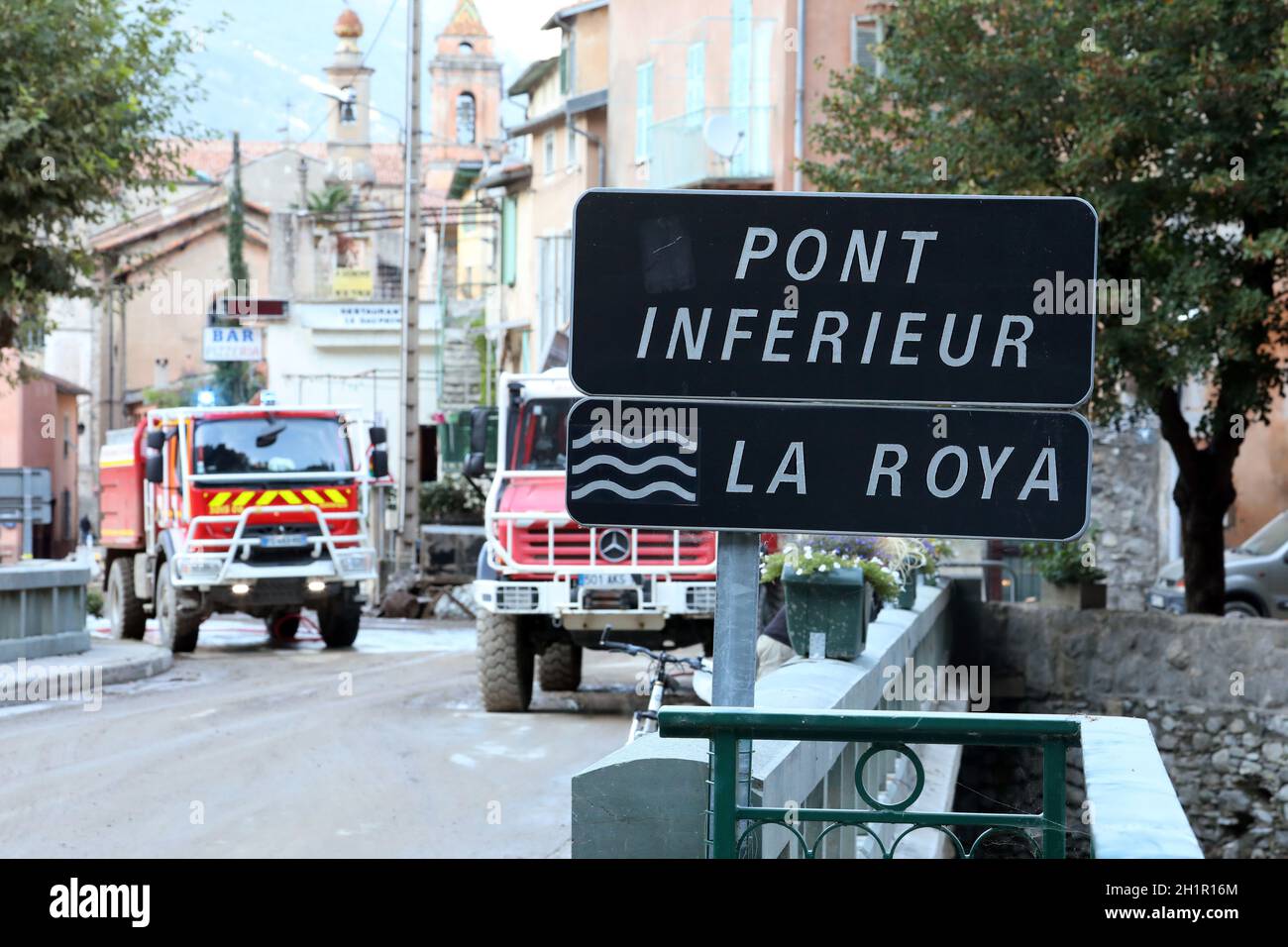 Breil-sur-Roya, France - 8 octobre 2020 : signe de la rivière Roya avec les camions rouges français en action en arrière-plan à Breil-sur-Roya, ville a été submerge Banque D'Images