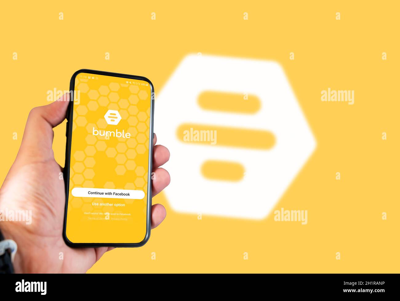 Rome, Italie, 16 février 2021: Main tenant un smartphone avec Bumble datant page de connexion de l'application sur l'écran avec le logo Bumble flou sur l'arrière-plan. Social Banque D'Images