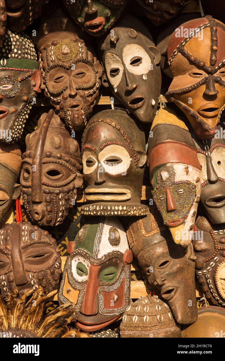 Masques africains traditionnels suspendus pour la vente dans une impasse du marché. Banque D'Images