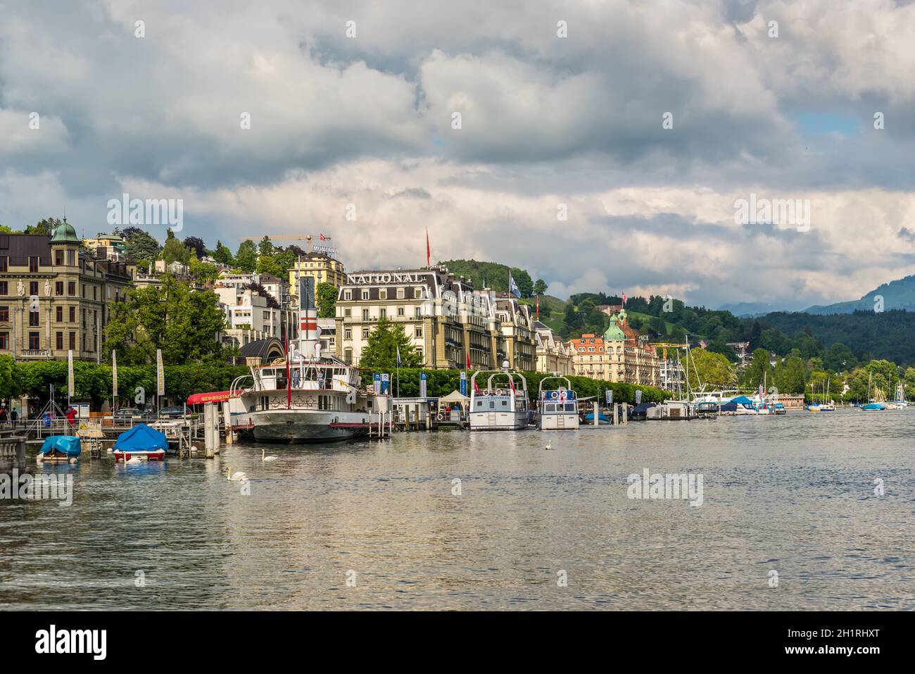 Lucerne, Suisse - 24 mai 2016 : Grand Hotel National et les bâtiments le long du lac des Quatre-Cantons, les gens en bateaux sur le lac par temps nuageux. Lucerne est Banque D'Images