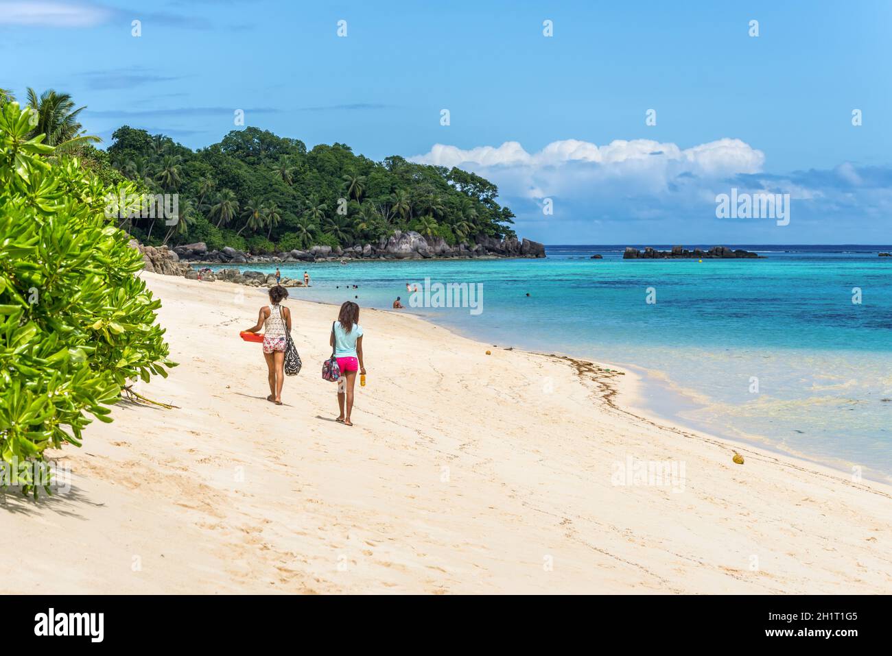 Anse Royale, l'île de Mahé, Seychelles - Décembre 15,2015 : les gens marcher dans le sable de la plage de Anse Royale spectaculaire et à l'arrière-plan certaines personnes Banque D'Images