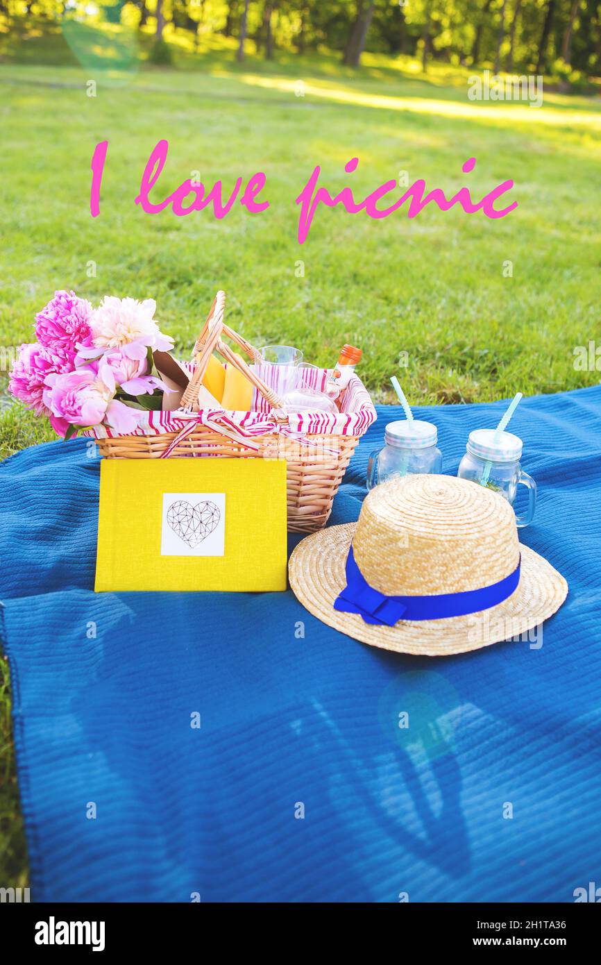 Belles fleurs dans un panier et un album jaune se coucher sur l'herbe-inscription pique-nique J'adore Banque D'Images