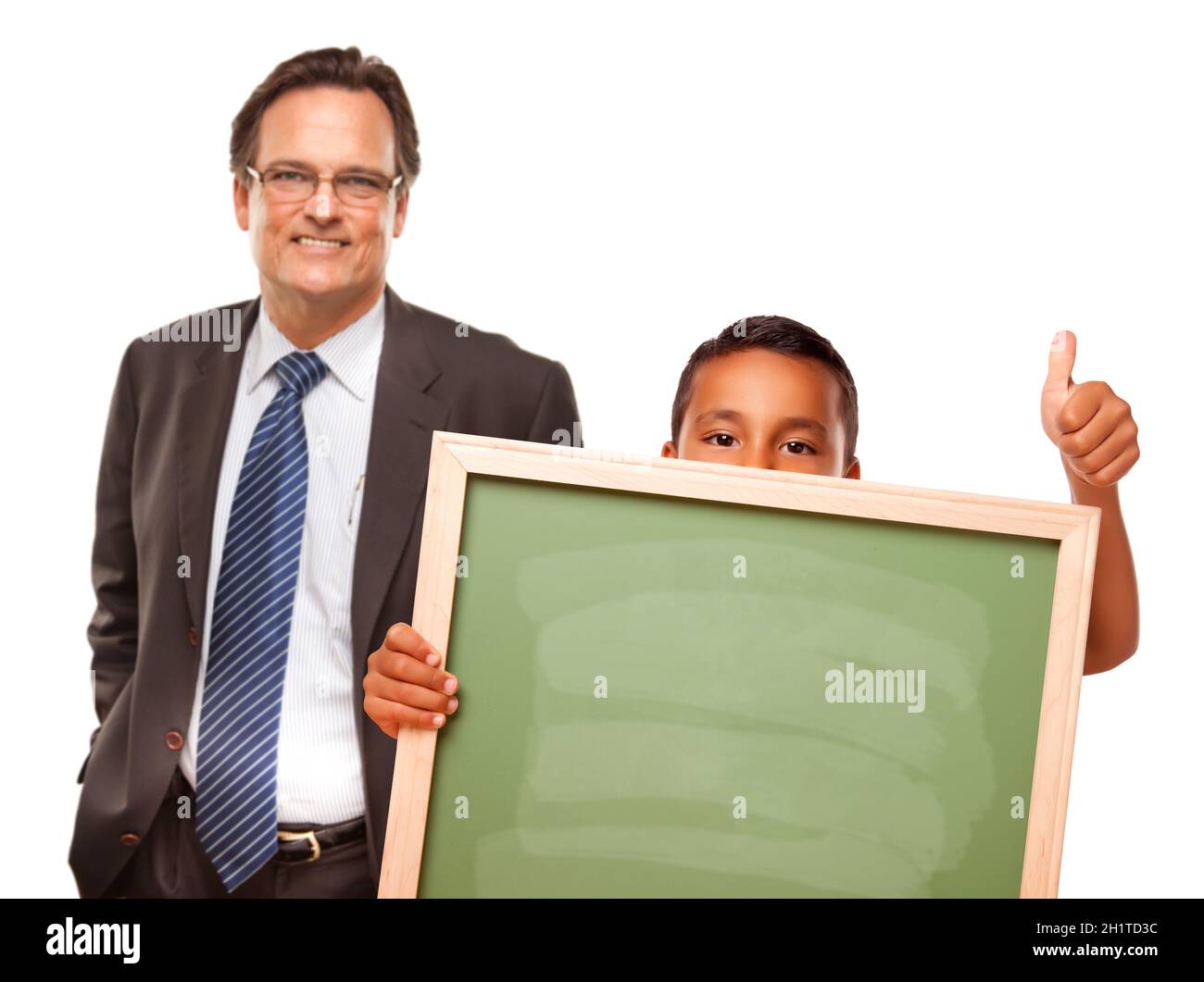 Petit garçon hispanique tenant un tableau de craie avec un enseignant de  sexe masculin isolé sur un fond blanc Photo Stock - Alamy