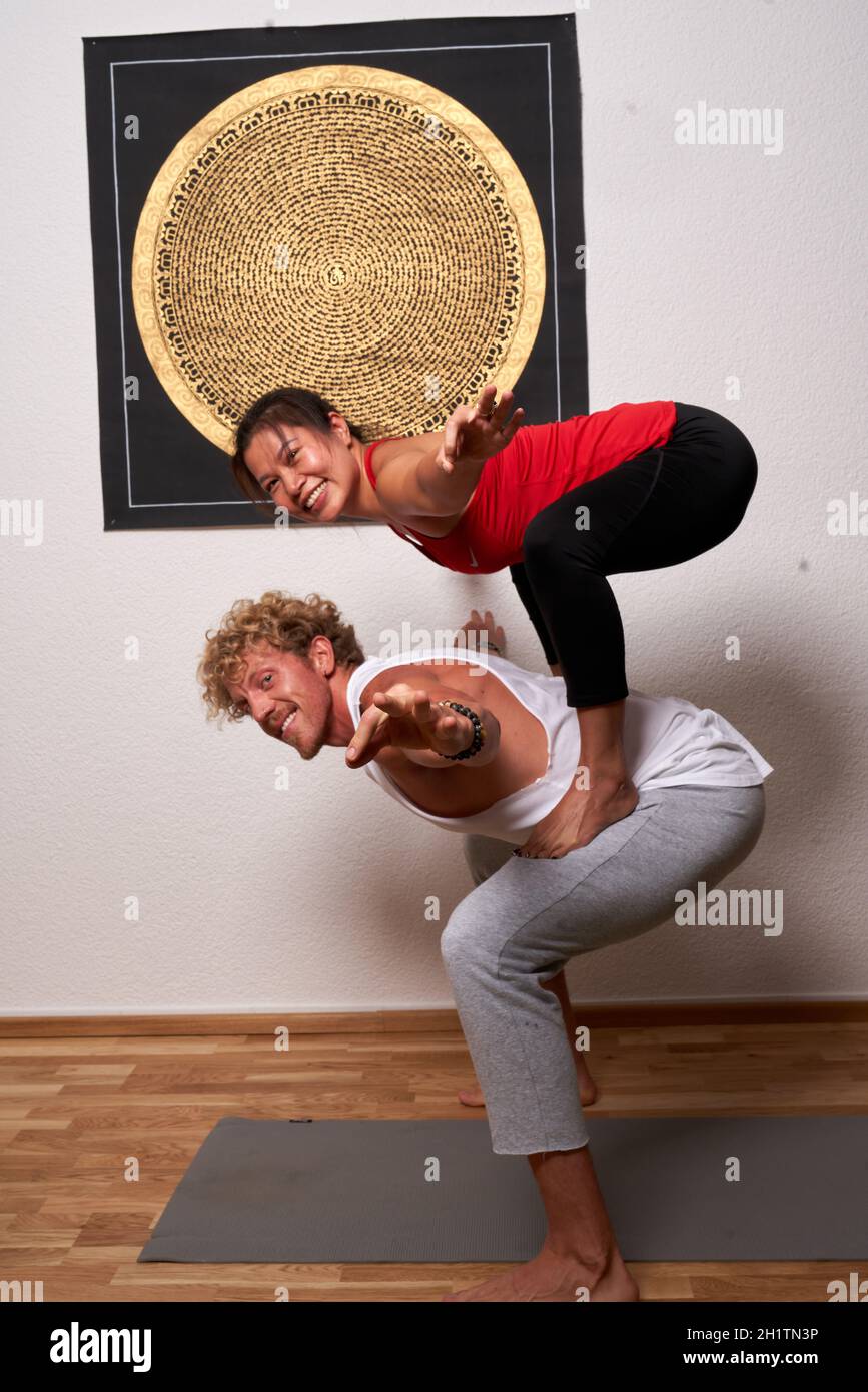 les femmes et les hommes pratiquent le yoga acrobatique Banque D'Images