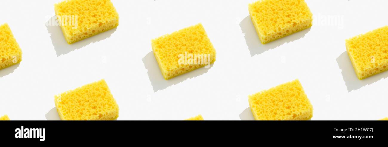 Mise en page créative avec éponge jaune pour laver la vaisselle sur fond gris Banque D'Images