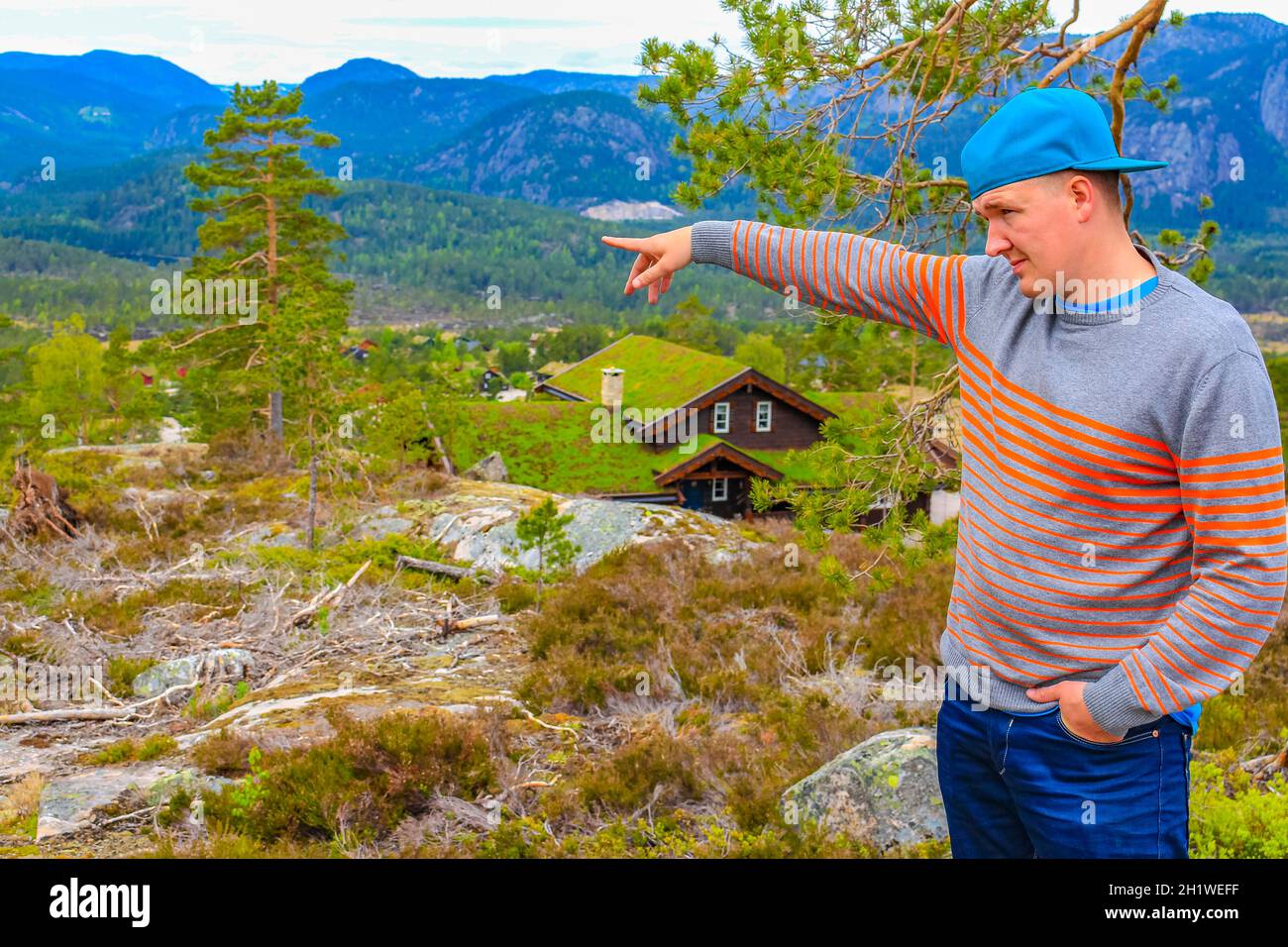 Un jeune randonneur montre le paysage des chalets de montagnes norvégiennes de Treungen à Nissedal Norvège. Banque D'Images