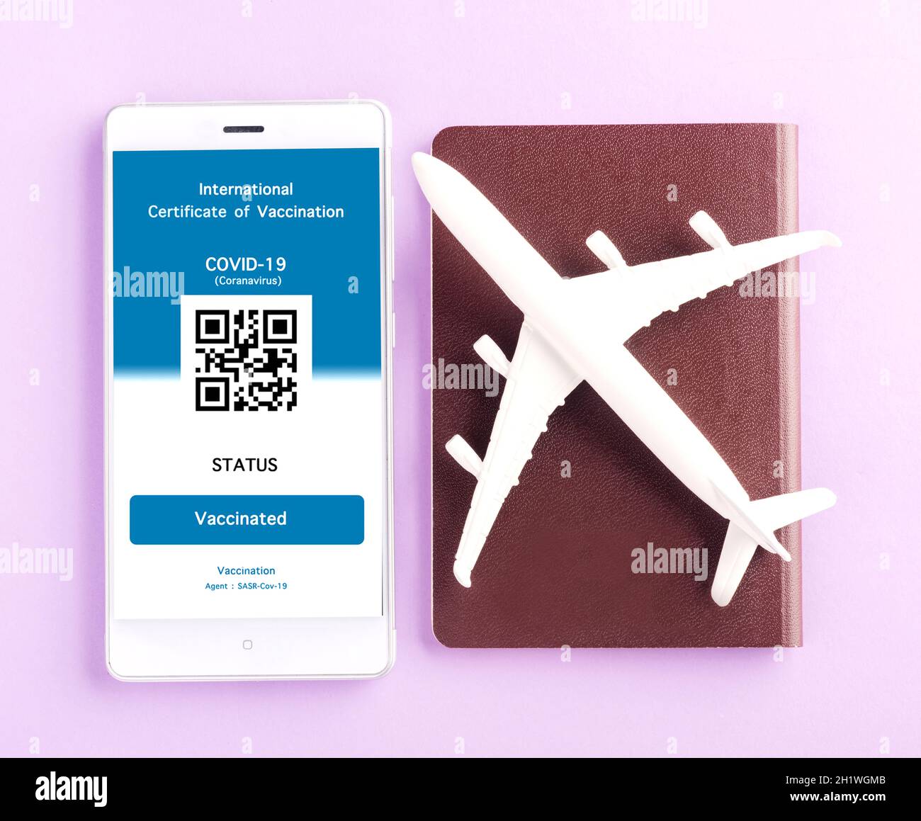 Modèle d'avion, passeport et carte d'immunité sont arrangés application sur smartphone sur fond violet, concept de Voyage pendant la digita pandémique Covid-19 Banque D'Images