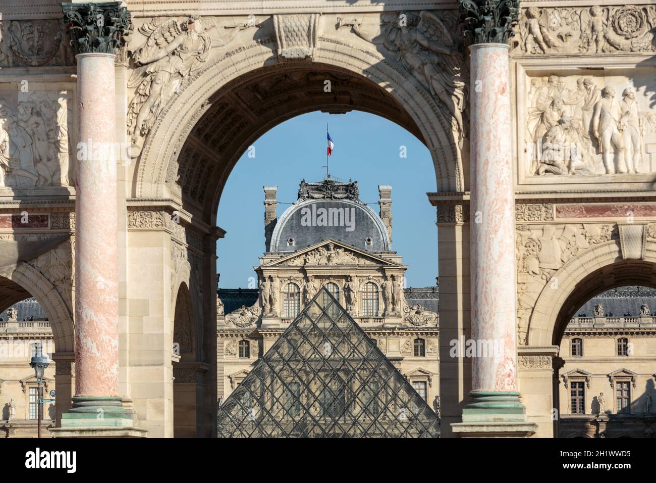 Paris - Arc de Triomphe et la Pyramide de verre au Louvre. Le Louvre est l'un des plus grand musée du monde ; elle reçoit plus de 8 millions de visiteurs chaque année Banque D'Images