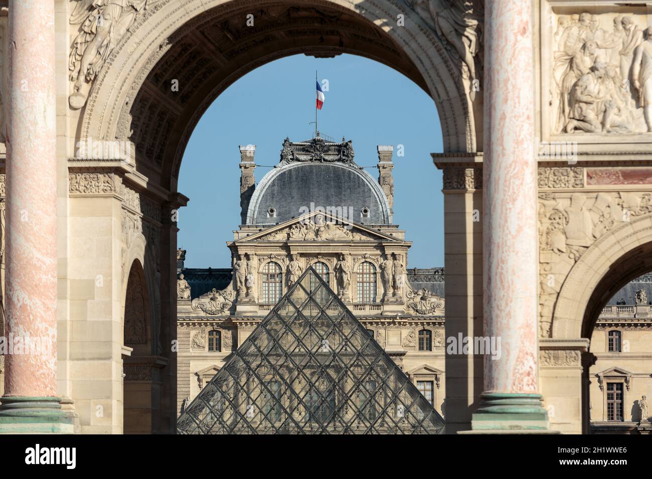 Paris - Arc de Triomphe et la Pyramide de verre au Louvre. Le Louvre est l'un des plus grand musée du monde ; elle reçoit plus de 8 millions de visiteurs chaque année Banque D'Images