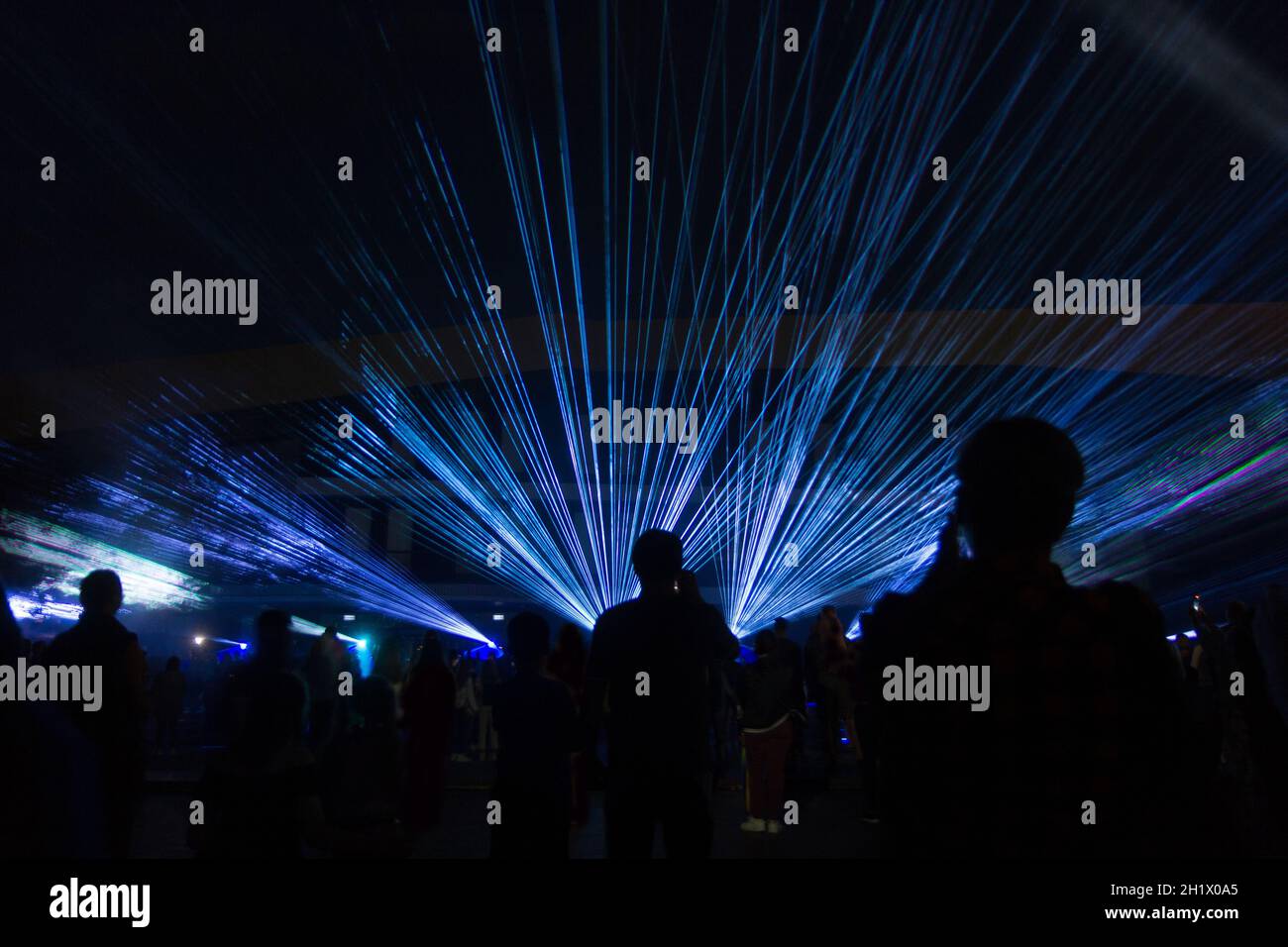 lumières laser bleues et silhouettes de personnes au concert Banque D'Images