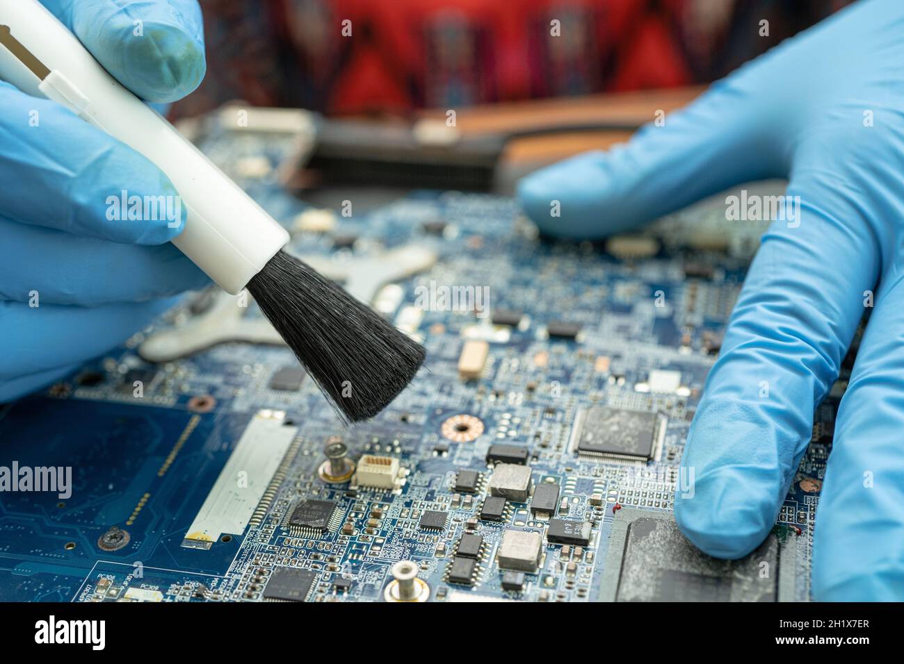 Le technicien utilise une brosse et une boule de soufflerie d'air pour nettoyer la poussière de l'ordinateur de la carte de circuit imprimé. Réparer la technologie de mise à niveau et de maintenance. Banque D'Images