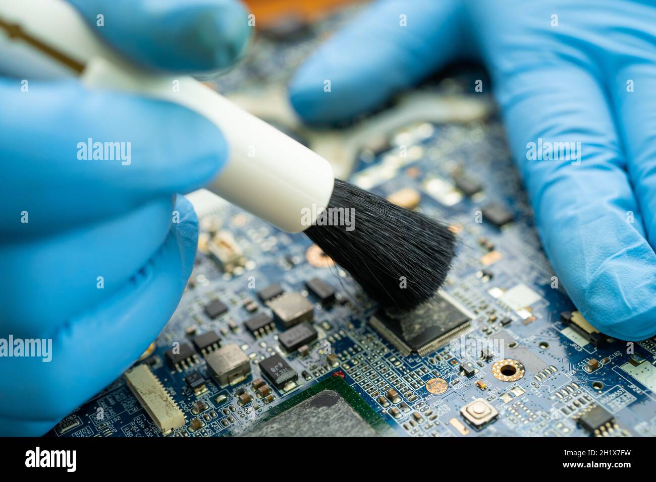 Le technicien utilise une brosse et une boule de soufflerie d'air pour nettoyer la poussière de l'ordinateur de la carte de circuit imprimé. Réparer la technologie de mise à niveau et de maintenance. Banque D'Images