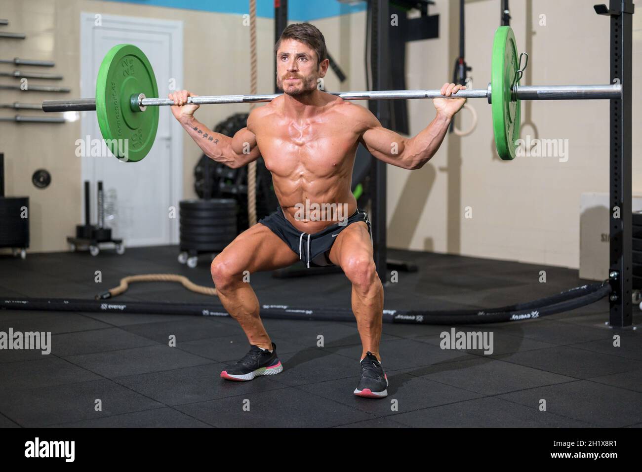 Hommes forts bodybuilder faisant au-dessus de la barre lourde dans la salle de gym moderne. Cours de formation fonctionnelle. Musculation et fitness. Photo de haute qualité Banque D'Images