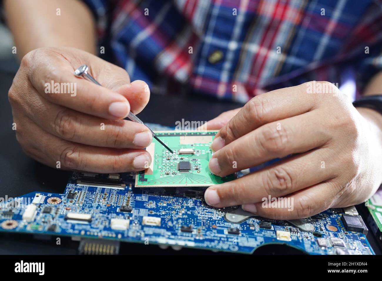 E-déchets, technicien réparant l'intérieur du disque dur par fer à souder. Circuit intégré. Concept de données, de matériel, de technicien et de technologie. Banque D'Images