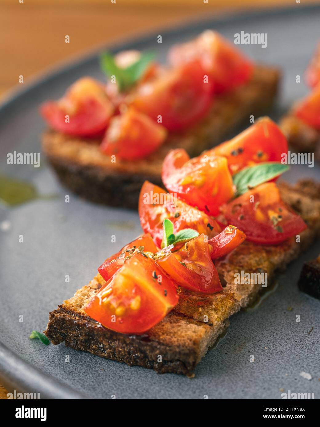 Bruschetta aux tomates servie sur une assiette avec des tomates cerises et du pain grillé Banque D'Images