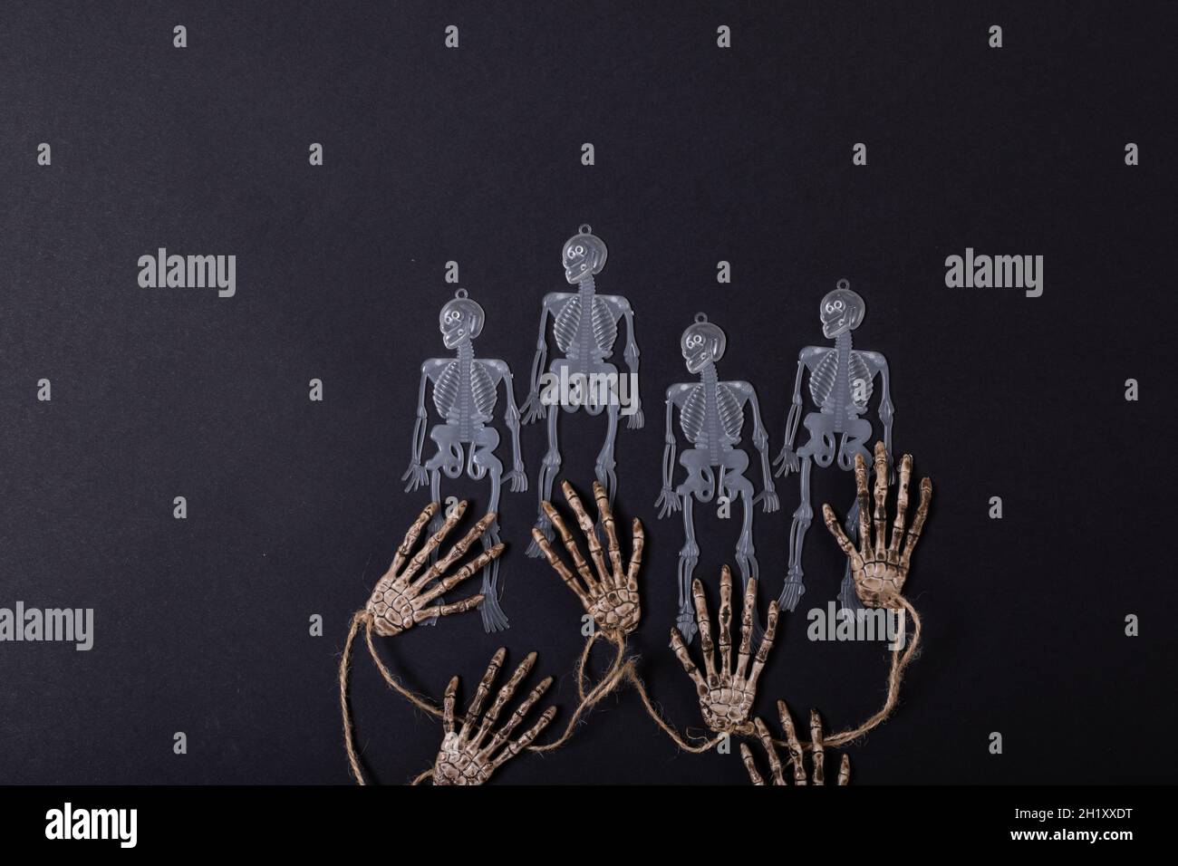 Composition de décorations d'halloween avec des squelettes et des mains sur fond noir Banque D'Images