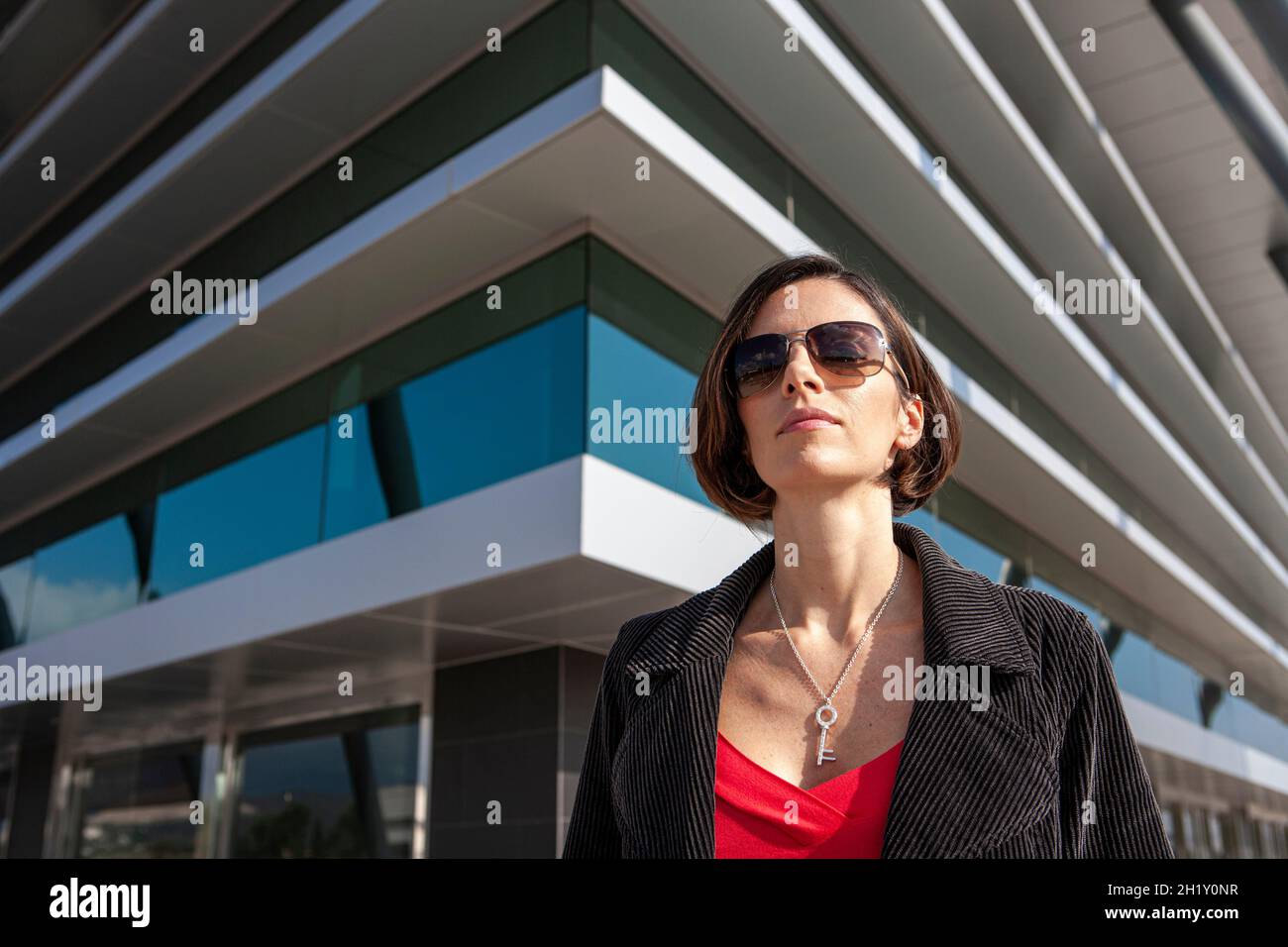 Femme d'affaires confiante debout à l'extérieur de son immeuble de bureaux Banque D'Images