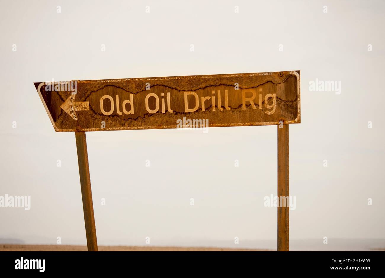 Panneau de signalisation rouillé pour « Old Oil Drill Rig ».Squelette de la côte, Namibie. Banque D'Images