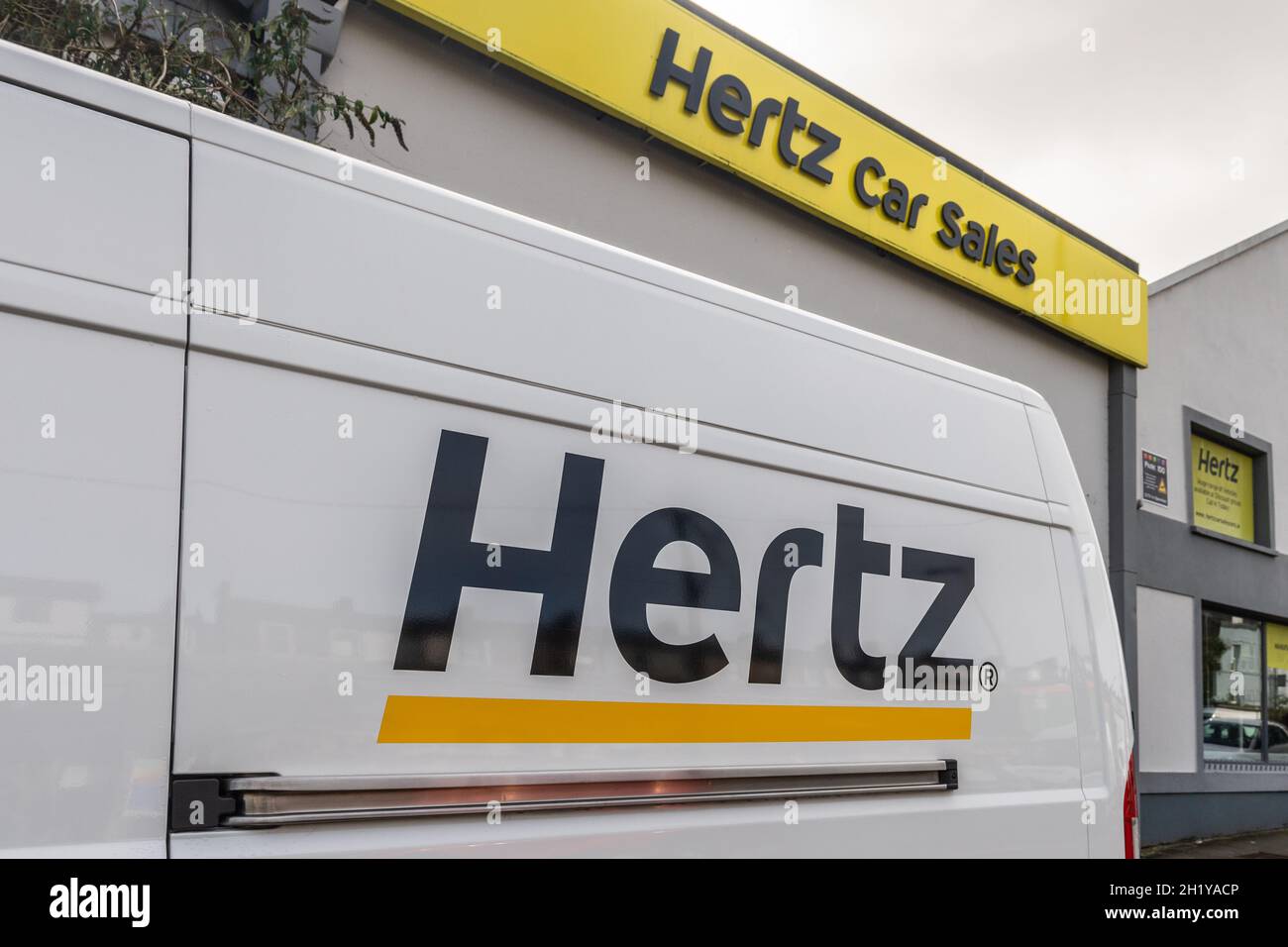 Logo Hertz sur le côté d'une fourgonnette à l'extérieur d'une agence de vente de voitures Hertz à Cork, en Irlande. Banque D'Images
