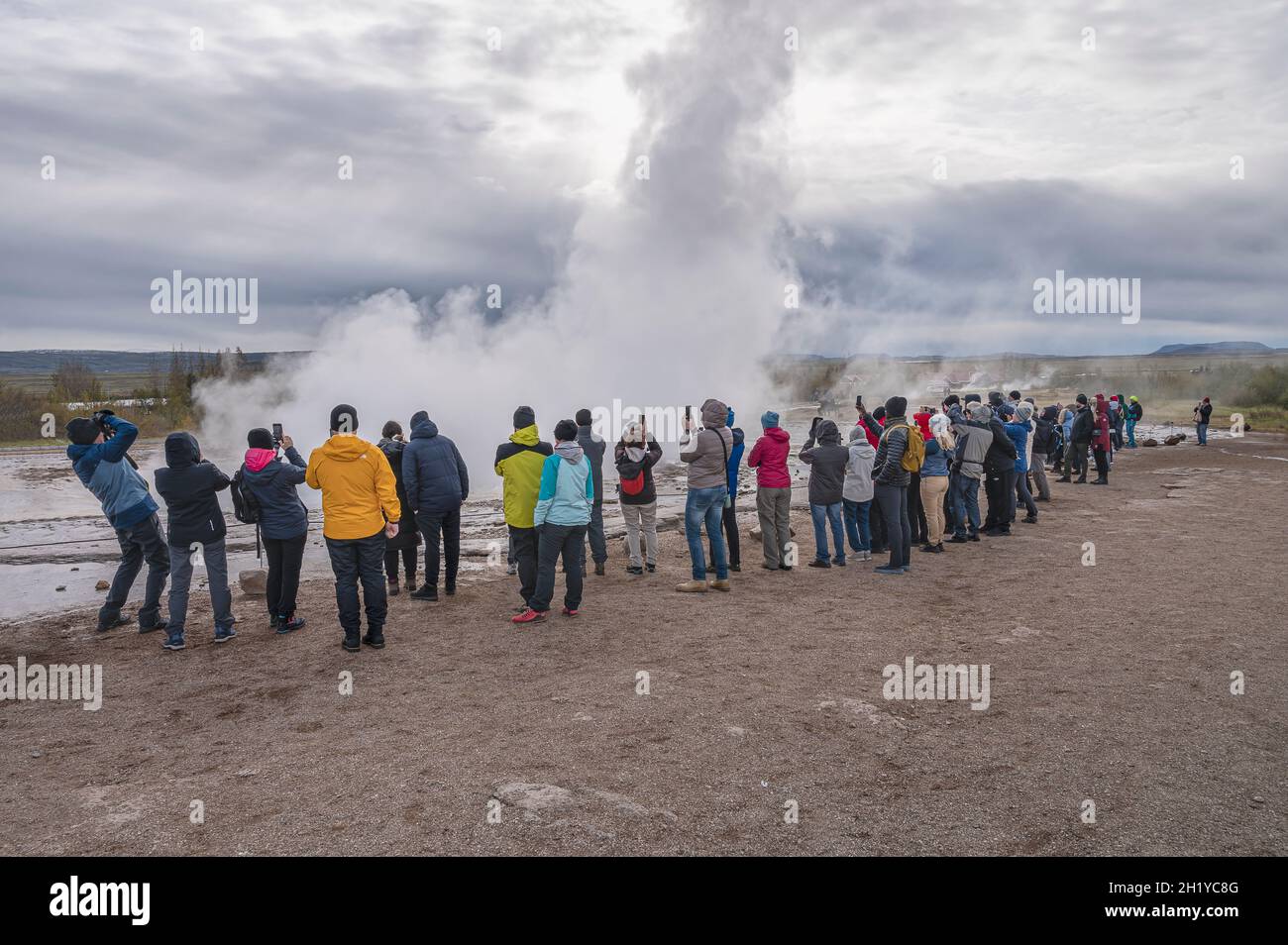 Strokkur Geyser, Islande – le 25 septembre 2021 : les gens se tiennent au bord du geyser en regardant son éruption Banque D'Images